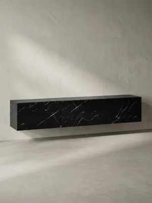 Schräge 3/4-Ansicht des wandmontierten Fernsehschranks in Schwarz-Marmor, die seine schlanke Tiefe von 30 cm und die durchgehende Marmor-Maserung zeigt._#sku_SAFWL6.865#