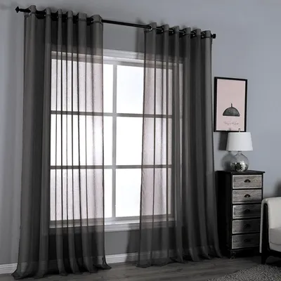 A window with dark gray sheer curtains hanging on a curtain rod.