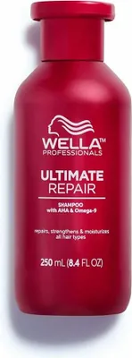 A red bottle of Wella Professionals Ultimate Repair Shampoo is shown against a white background.
