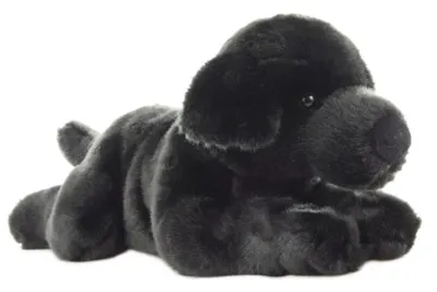 A plush toy black Labrador dog lying down on a white background.