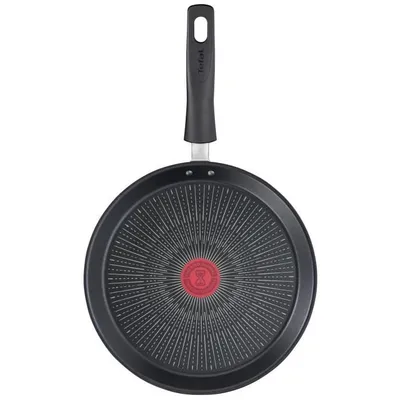 The back of a black Tefal crêpe pan with a red logo in the center and a black handle.