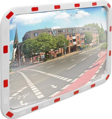 A convex mirror reflecting a street scene with buildings, trees, and road markings.