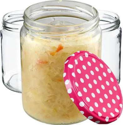 Three glass jars, one filled with sauerkraut, with a pink polka dot lid.