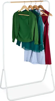 A white metal clothes rack with several garments hanging on it.