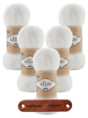 Five balls of white yarn are arranged in a cluster, with a small leather tag in the foreground.