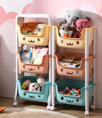 A multi-tiered storage shelf filled with toys and books, set against a pink and white cloud-patterned wall.