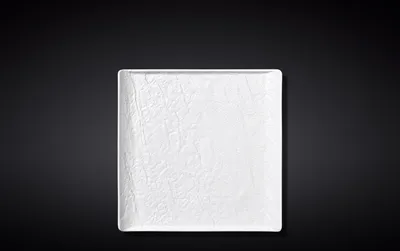 A white square plate with a textured surface is centered against a black background.