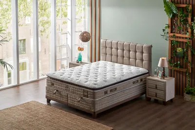 A bedroom scene with a bed, nightstand, and window.