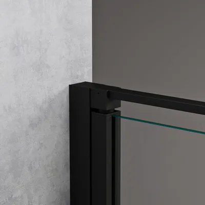 A close-up view of a black framed shower door with clear glass, showing the corner joint and a section of the glass.