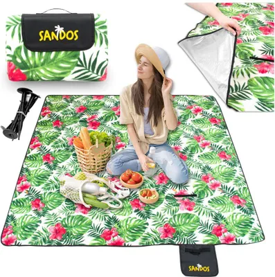 A woman is sitting on a picnic blanket with food and a basket.