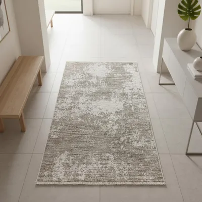 Zdjęcie produktu dla Wytrzymały dywan w kolorze beżowym, kremowym, z abstrakcyjnym wzorem i dekoracyjnymi frędzlami. Wymiary: 80 x 150 cm