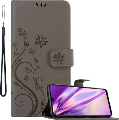 A grey flip phone case with a floral and butterfly design is shown, with a smartphone placed in front of it.