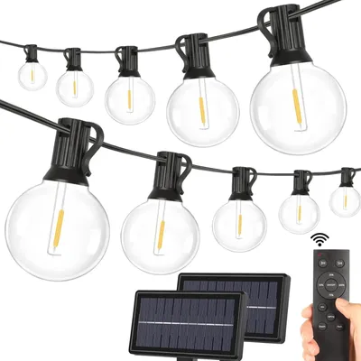 Solarbetriebene Lichterkette mit klaren Glaskugeln und schwarzer Verkabelung, zwei Solarmodulen und einer Fernbedienung in einer Hand
