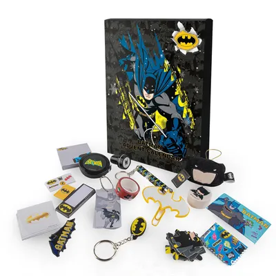 A collection of Batman-themed advent calendar items are displayed around a closed advent calendar. The items include keychains, stickers, a tape dispenser, and other small accessories.