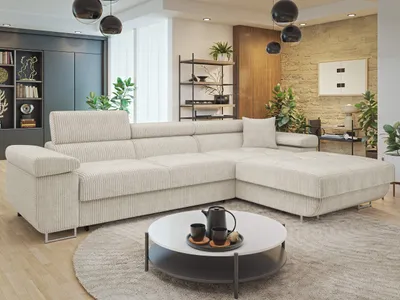 A modern living room with a large sectional sofa, coffee table, and decorative elements.