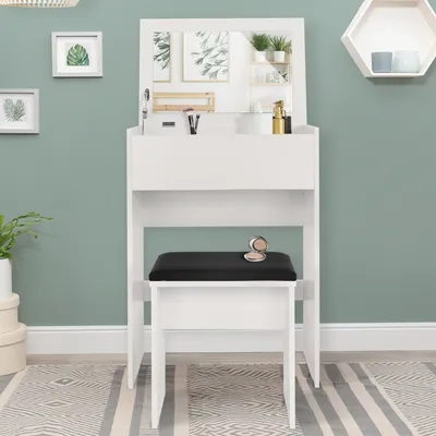A white vanity table with a mirror and a black stool in front of it, set against a green wall.