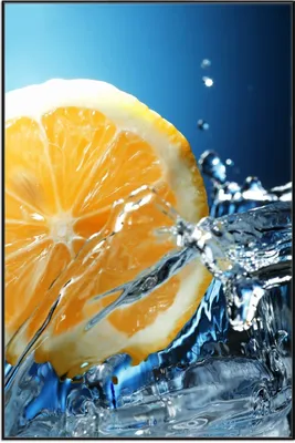 Produktbild von Wallario Wandbild Orange in spritzigem Wasser vor blauem Hintergrund, Größe: 61 x 91,50 cm, Poster mit schwarzem Aluminiumrahmen