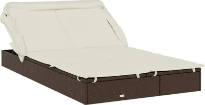 A brown rattan double chaise lounge with cream cushions and an adjustable canopy.