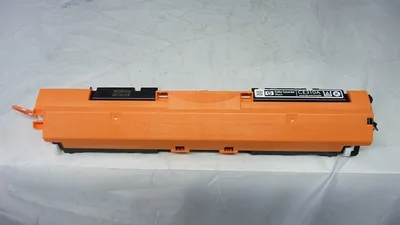 A toner cartridge is placed on a white surface.