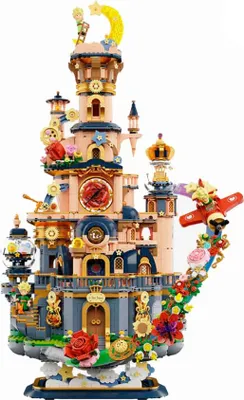 A detailed model of a whimsical castle with a teapot-shaped base, adorned with flowers and a small airplane.