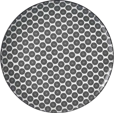A top-down view of a round dinner plate with a black and white circular pattern.