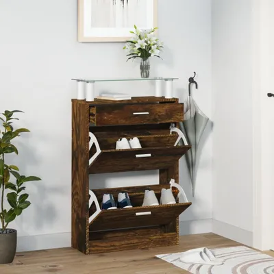A shoe cabinet with shoes inside, placed against a light gray wall with a plant to the left and a door to the right.