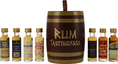 A collection of miniature rum bottles arranged in front of a decorative rum barrel.