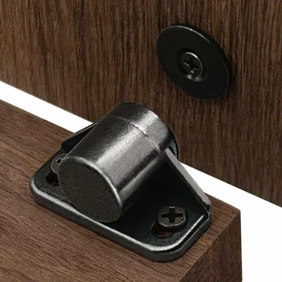 A close-up view of two magnetic door catches mounted on wooden surfaces.