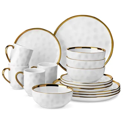 A set of white porcelain dishes with gold trim, including plates, bowls, and mugs, arranged on a white background.