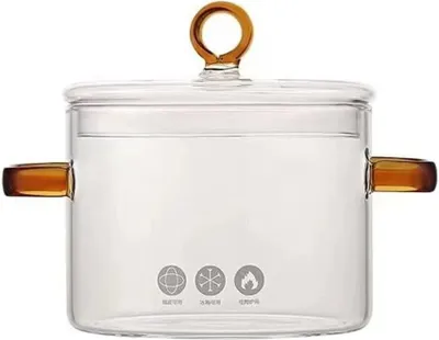 A clear glass pot with amber handles and lid knob sits on a white background.
