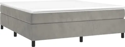 A boxspring bed with a mattress on top, shown from a side angle on a white background.