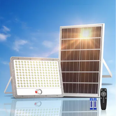 A solar-powered LED floodlight and its solar panel are displayed against a blue sky with clouds.