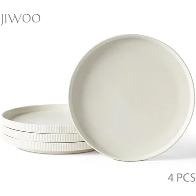 A stack of four plates with one plate in the foreground.