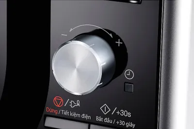 A close-up view of a control knob and buttons on a black appliance, likely a microwave or oven.