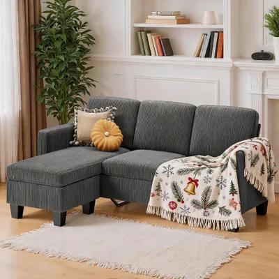 A sectional sofa with decorative pillows and a festive throw blanket is shown in a living room setting.