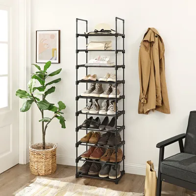 A shoe rack with shoes, a plant, and a coat hanging on the wall.