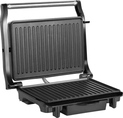 An open electric panini grill with a ribbed surface.
