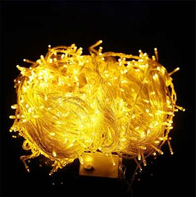A tangled ball of yellow LED string lights on a black background.