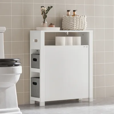 A white storage cabinet with two gray baskets is placed next to a toilet in a tiled bathroom.