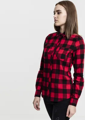 A woman is shown from the side wearing a red and black checkered flannel shirt.