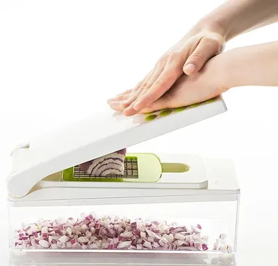 A person is using a kitchen gadget to chop an onion.