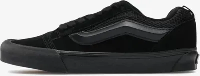 A side view of a black Vans sneaker.