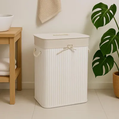 A laundry basket in a bathroom setting next to a sink and a plant.