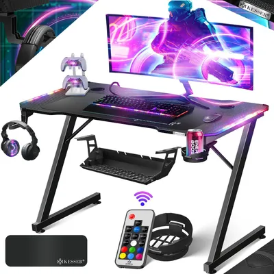 A gaming desk setup with a monitor, keyboard, mouse, headphones, and accessories, illuminated by LED lights.