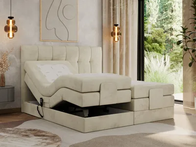 A bedroom scene featuring an adjustable bed with a tufted headboard, set against a backdrop of curtains and a window overlooking greenery. The bed is elevated, revealing storage space underneath.