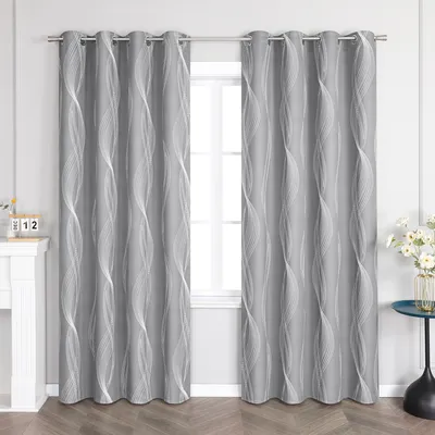 A pair of gray curtains with a white wavy pattern hanging in front of a window, with a fireplace and a small table with flowers visible.
