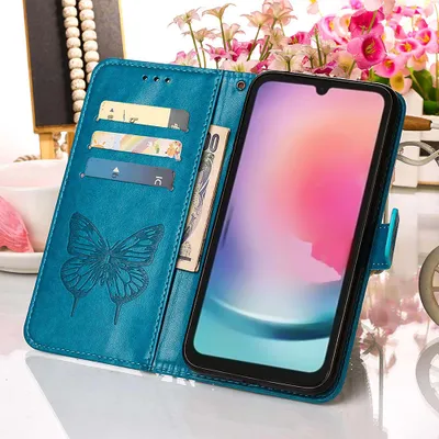 A blue leather flip case for a smartphone, with card slots and a butterfly embossed design, is shown open with the phone screen displaying a colorful abstract image. The background includes blurred flowers and a white cup.