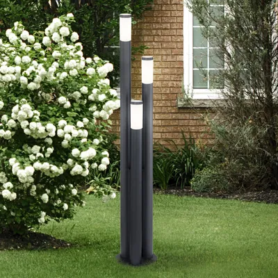 A garden scene with a three-pillar lamp and a flowering bush.