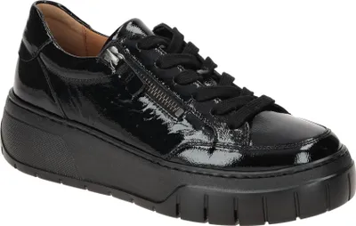 A studio shot of a single black patent leather sneaker with a thick sole and laces.