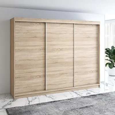 A three-door sliding wardrobe with a wood-grain finish, shown in a room setting with a rug and marble-patterned floor.